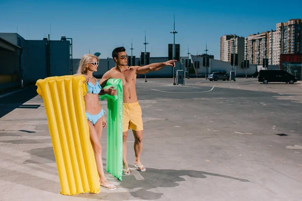 Счастливая Молодая Пара Пляжной Одежде Надувными Кроватями Парковке — Бесплатное стоковое фото
