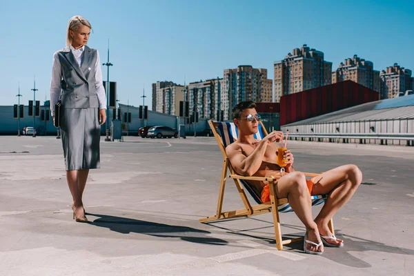 Bonito Jovem Relaxante Sol Espreguiçadeira Enquanto Sua Senhora Chefe Terno — Fotografia de Stock Grátis