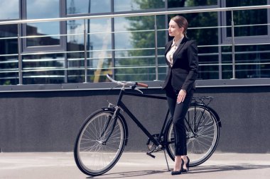 takım elbise ve yüksek topuklu retro Bisiklet Street yakınında duran genç iş kadını