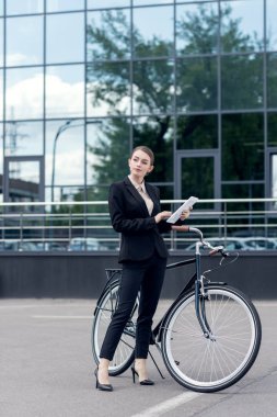 retro Bisiklet Street yakınında duran elinde dijital tablet ile genç iş kadını
