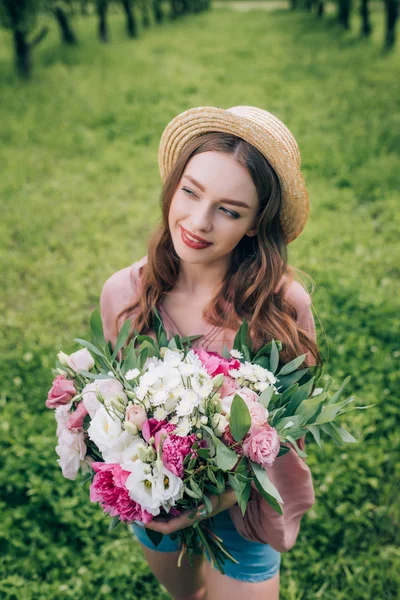 公園に目をそむけるの花の花束と帽子で笑顔美人のハイアングル — ストック写真