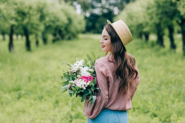 Visão Traseira Mulher Sorridente Chapéu Com Buquê Flores Mãos Parque — Fotografia de Stock