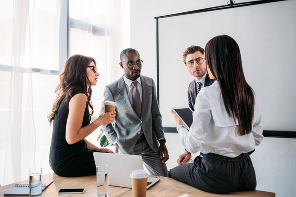 group of multiracial business coworkers in formal wear discussing new business plan in office