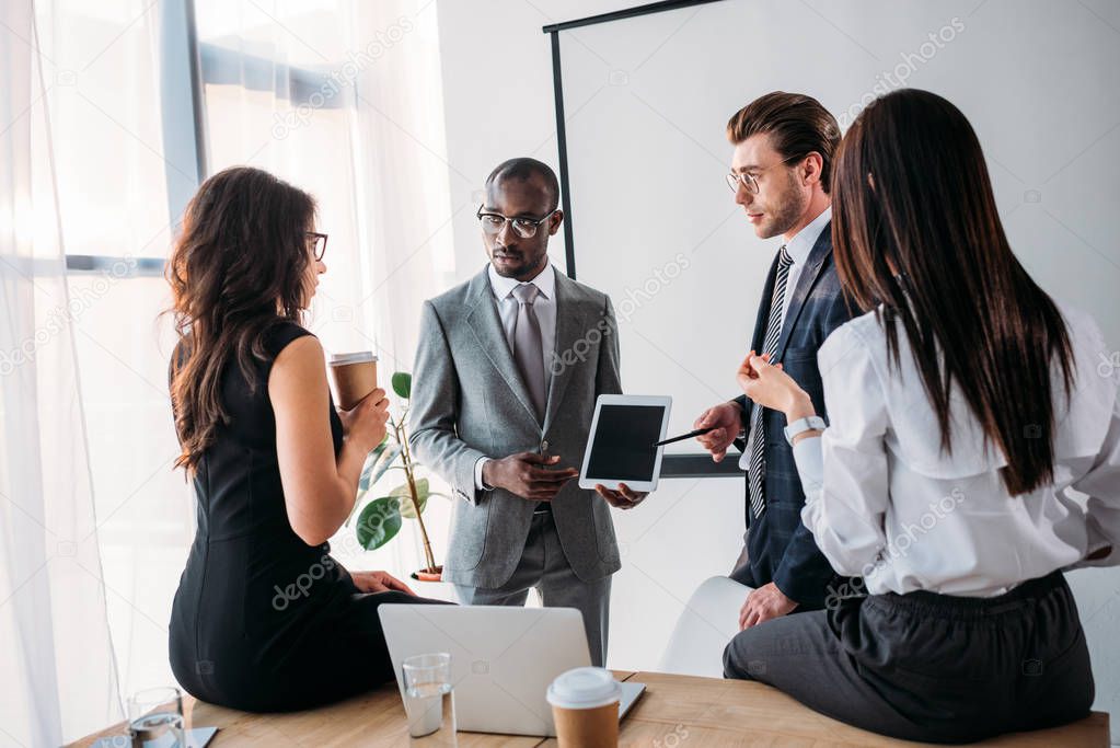 group of multiracial business coworkers in formal wear discussing new business plan in office