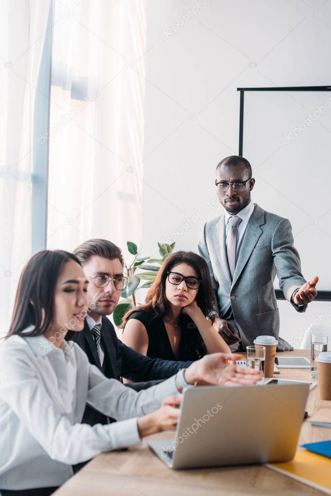 selective focus of multicultural business people having business meeting in office