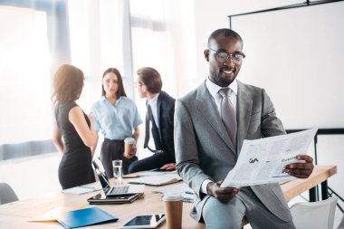 Afrika kökenli Amerikalı işadamı gazete ve office İşyerinde meslektaşları okuma seçici odak