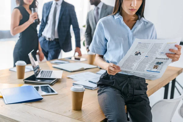 Visión Parcial Mujer Negocios Leyendo Periódico Colegas Detrás Cargo — Foto de Stock