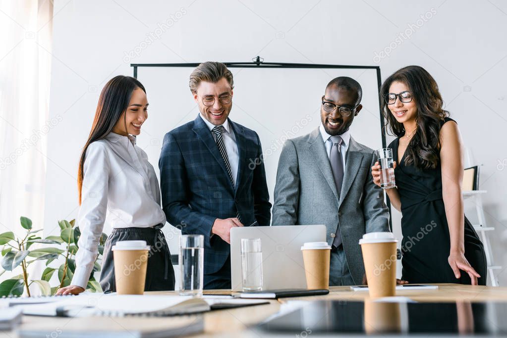 portrait of multicultural smiling business people having business meeting in office