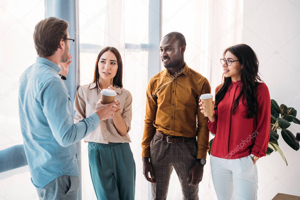 group of multicultural business people having conversation during coffee break in office