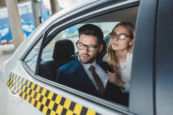 Elegante Giovane Coppia Abbigliamento Formale Occhiali Guardando Lontano Mentre Seduti — Foto Stock