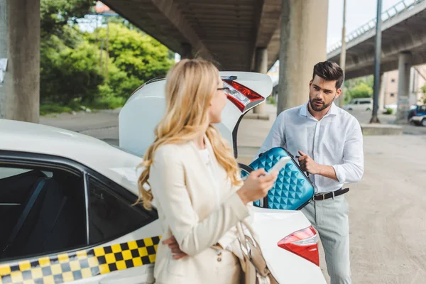 Молодая Женщина Смотрит Мужчину Положить Чемодан Багажник Автомобиля — стоковое фото