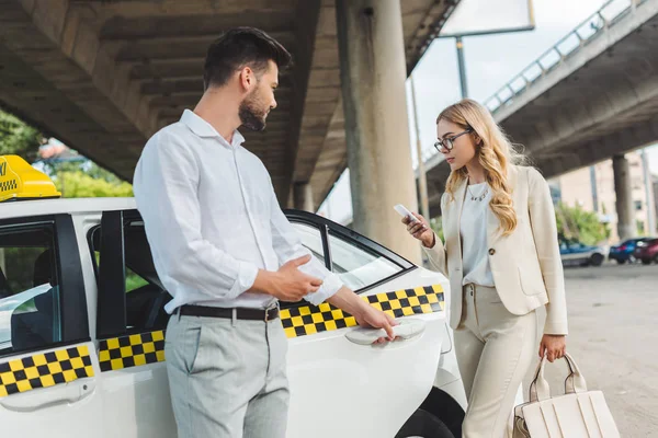 Joven Hombre Abriendo Puerta Taxi Hermosa Mujer Gafas Con Smartphone — Foto de Stock