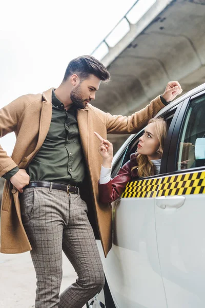 Mujer Joven Seria Sentada Taxi Señalando Con Dedo Hombre Apoyado —  Fotos de Stock