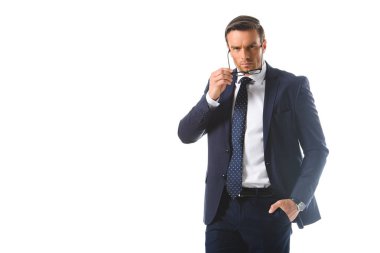 Beyaz arka plan üzerinde izole gözlük koyarak cebinde el ile ciddi iş adamı 