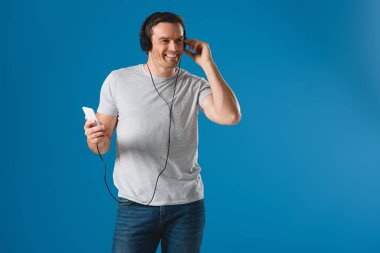 smartphone ve uzak mavi izole seyir ile müzik dinleme Kulaklığımda mutlu adam
