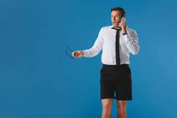 Homem Chocado Falando Por Smartphone Olhando Para Longe Isolado Azul — Fotografia de Stock
