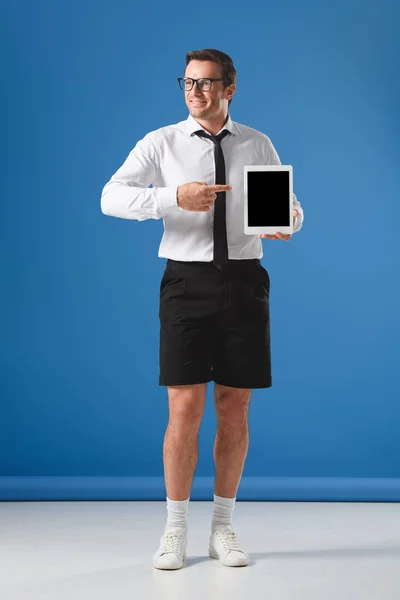 Smiling Man Eyeglasses Shorts Pointing Finger Digital Tablet Blank Screen — Free Stock Photo