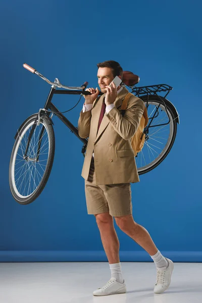 Uomo Sorridente Che Porta Bicicletta Parla Con Smartphone Blu — Foto stock gratuita