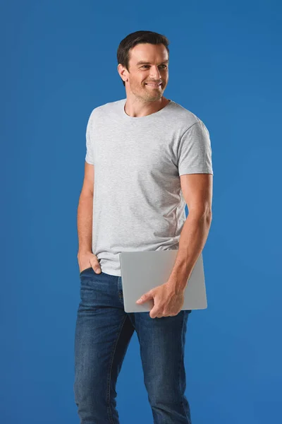 Happy Handsome Man Holding Laptop Looking Away Isolated Blue — Free Stock Photo