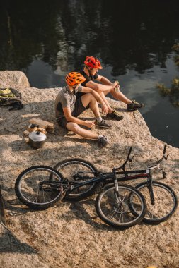 yüksek açılı görünüş deneme bisikletçileri günlükleri, kazan ve dağ yakın dinlenme Nehri üzerinde kayalık uçurum döngüleri