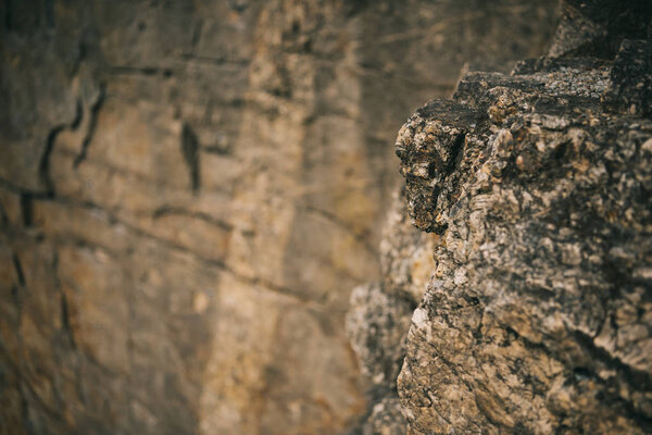 selective focus of surface of rocky cliff on blurred background