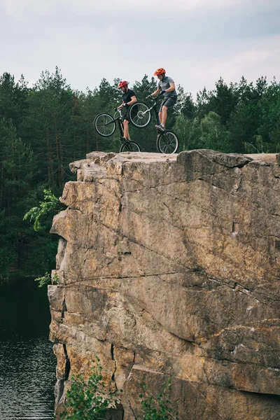 Two Male Extreme Cyclists Protective Helmets Jumping Mountain Bicycles Rocky — Stock Photo, Image