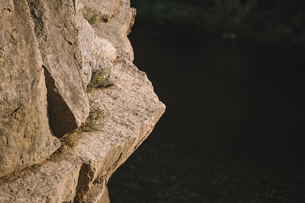 selective focus of rocky cliff over river 