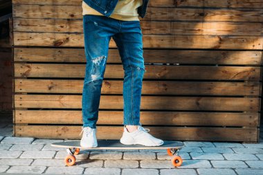 şık adam sokakta longboard üzerinde ayakta kısmi görünümünü