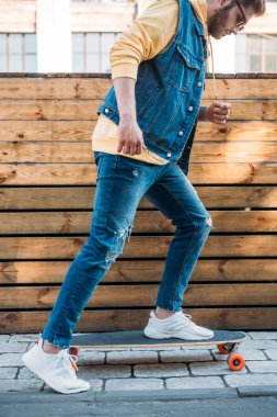 şehirde longboard üzerinde güneş gözlüğü şık adam yan görünüm