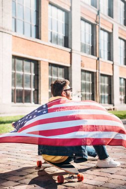 Amerikan bayrağı longboard sokakta oturan genç adam görünümünü geri