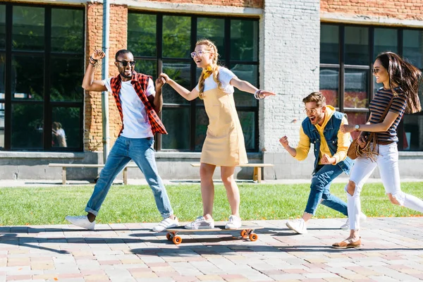 Amigos Multirraciales Con Tablero Largo Que Divierten Mientras Que Pasan — Foto de stock gratuita