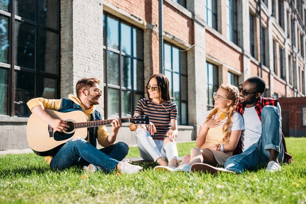 Interracial Group Friends Acoustic Guitar Resting Green Grass Summer Day — Stock Photo, Image