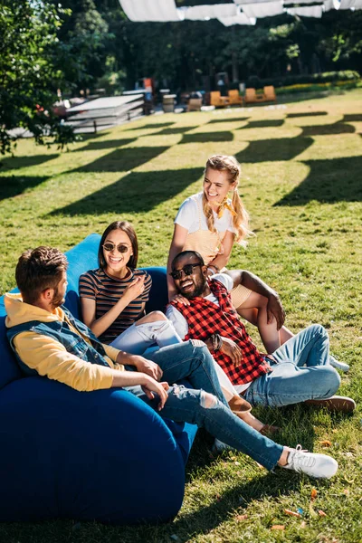 Lächelnde Interrassische Freunde Die Gemeinsam Auf Blauem Sofa Park Liegen — Stockfoto