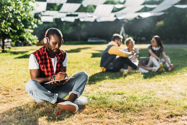 Selective Focus African American Man Headphones Notebook Resting Green Grass — Stock Photo, Image