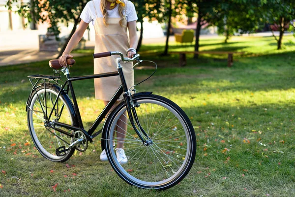 妇女的部分看法在公园的复古自行车站立 — 免费的图库照片