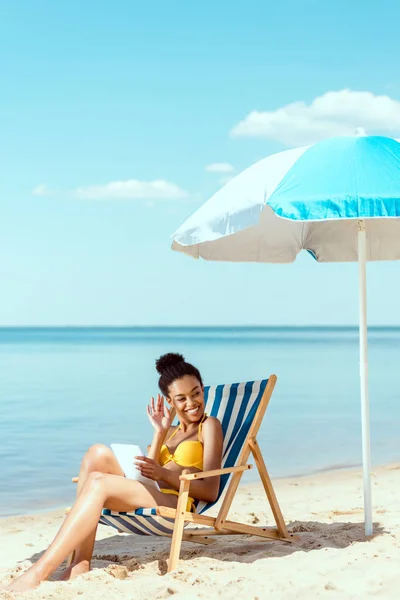 Mujer Afroamericana Con Tableta Digital Relajándose Tumbona Saludando Mano Bajo — Foto de Stock