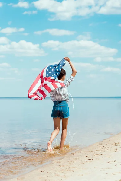 Vista Trasera Mujer Joven Corriendo Agua Mar Con Bandera Americana — Foto de Stock