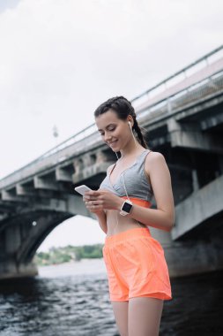 güzel genç sporcumuz smartphone kulaklık ve smartwatch ile kullanma