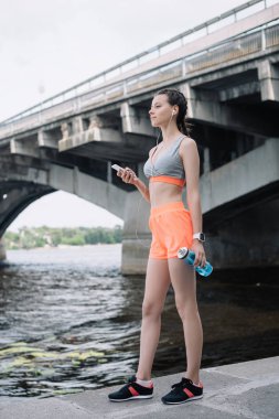 Genç sporcumuz Smartphone, earphones ve spor şişe tutan  
