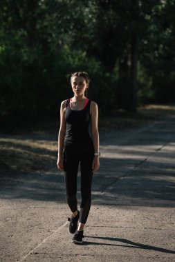 atletik kadında yoldaki parkta yürüyüş spor giyim