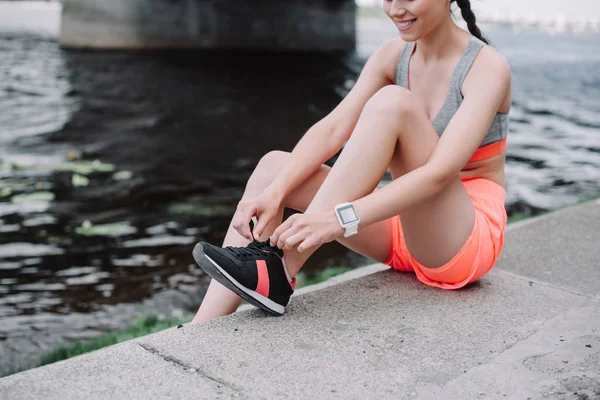 Ausgeschnittene Ansicht Einer Sportlerin Die Schnürsenkel Turnschuhen Bindet Und Kai — kostenloses Stockfoto