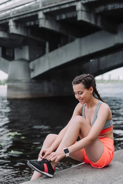 Glimlachend Sportvrouw Koppelverkoop Veters Sneakers Zittend Kade — Stockfoto