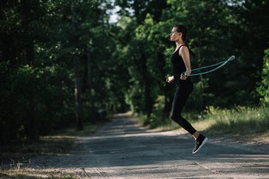 çekici sportif kadın parkta yoldaki ip atlama ile eğitim