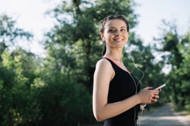 kulaklık ve smartphone ile güzel gülümseyen sporcumuz dinleme müzik