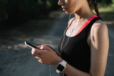 kulaklık, smartwatch ve akıllı telefon ile genç sporcumuz görünümünü kırpılmış
