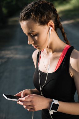 kulaklık, smartwatch ve akıllı telefon ile güzel sporcumuz