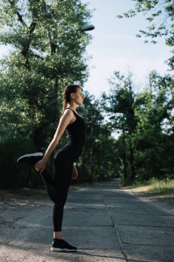 egzersiz ve Park yolundaki bacak Germe çekici sporcumuz 