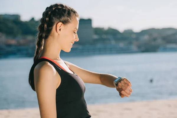 Leende Idrottskvinna Titta Smart Klocka Stranden — Stockfoto