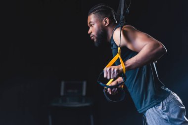 direnç bands ile egzersiz ve uzağa arıyorsunuz kas Afrikalı-Amerikalı adam yan görünüm