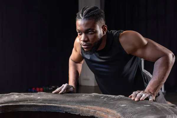 Seriöser Afrikanisch Amerikanischer Sportler Trainiert Mit Reifen Und Schaut Weg — Stockfoto